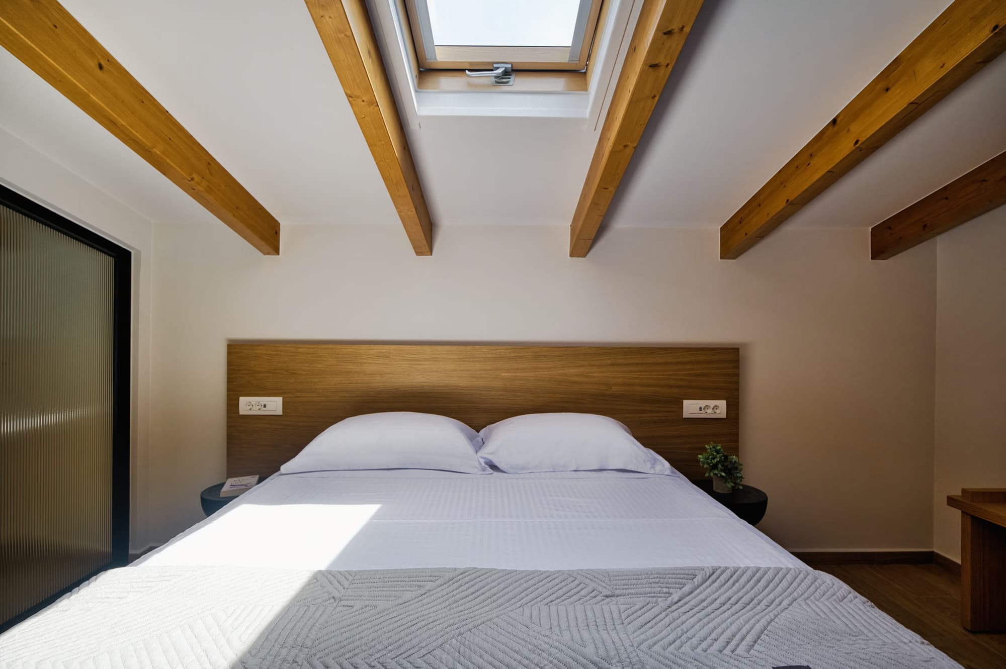 Revello Villa 1 beamed bedroom with a skylight over the bed