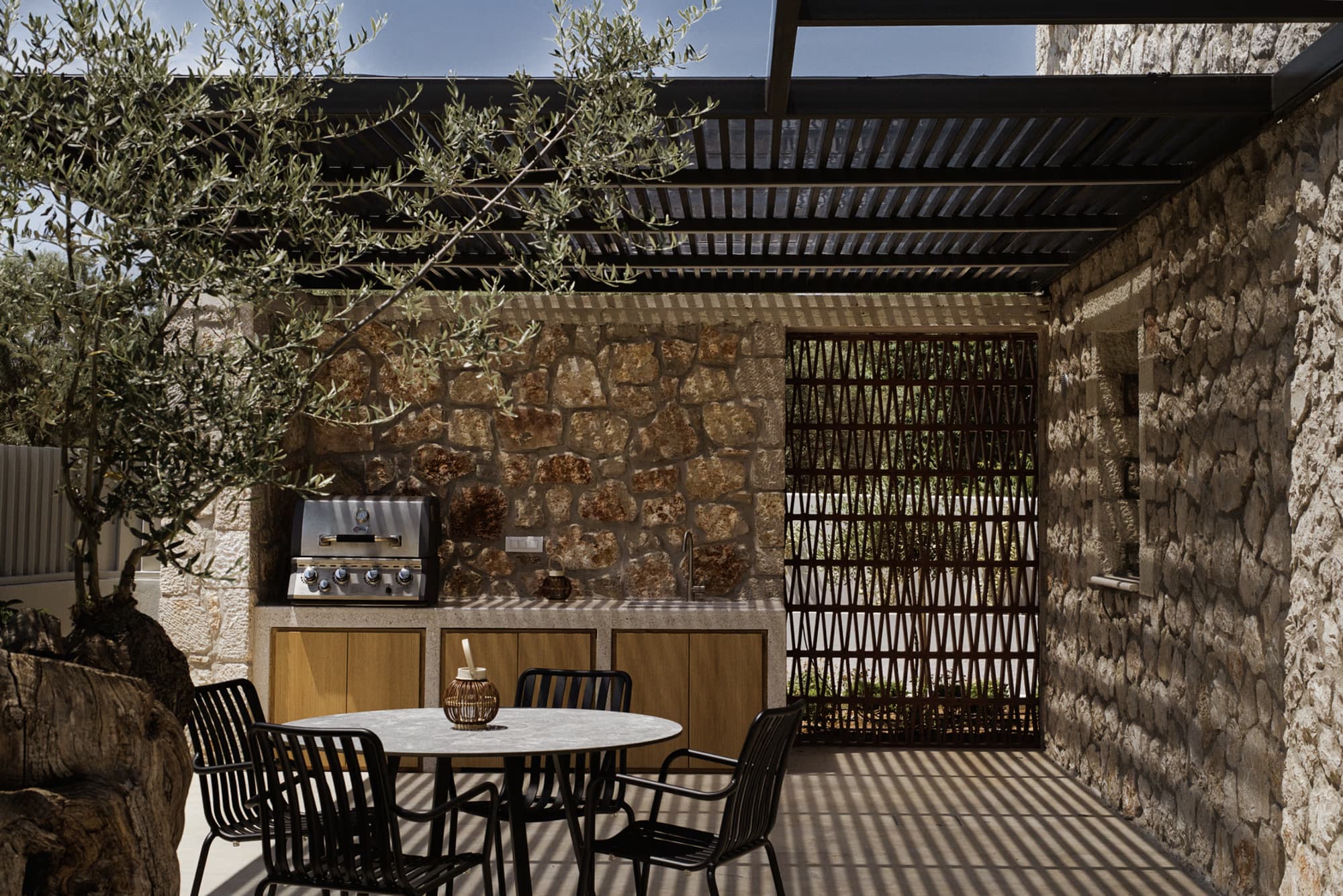 Revello Villa 1 outdoor dining and BBQ under the stone pergola