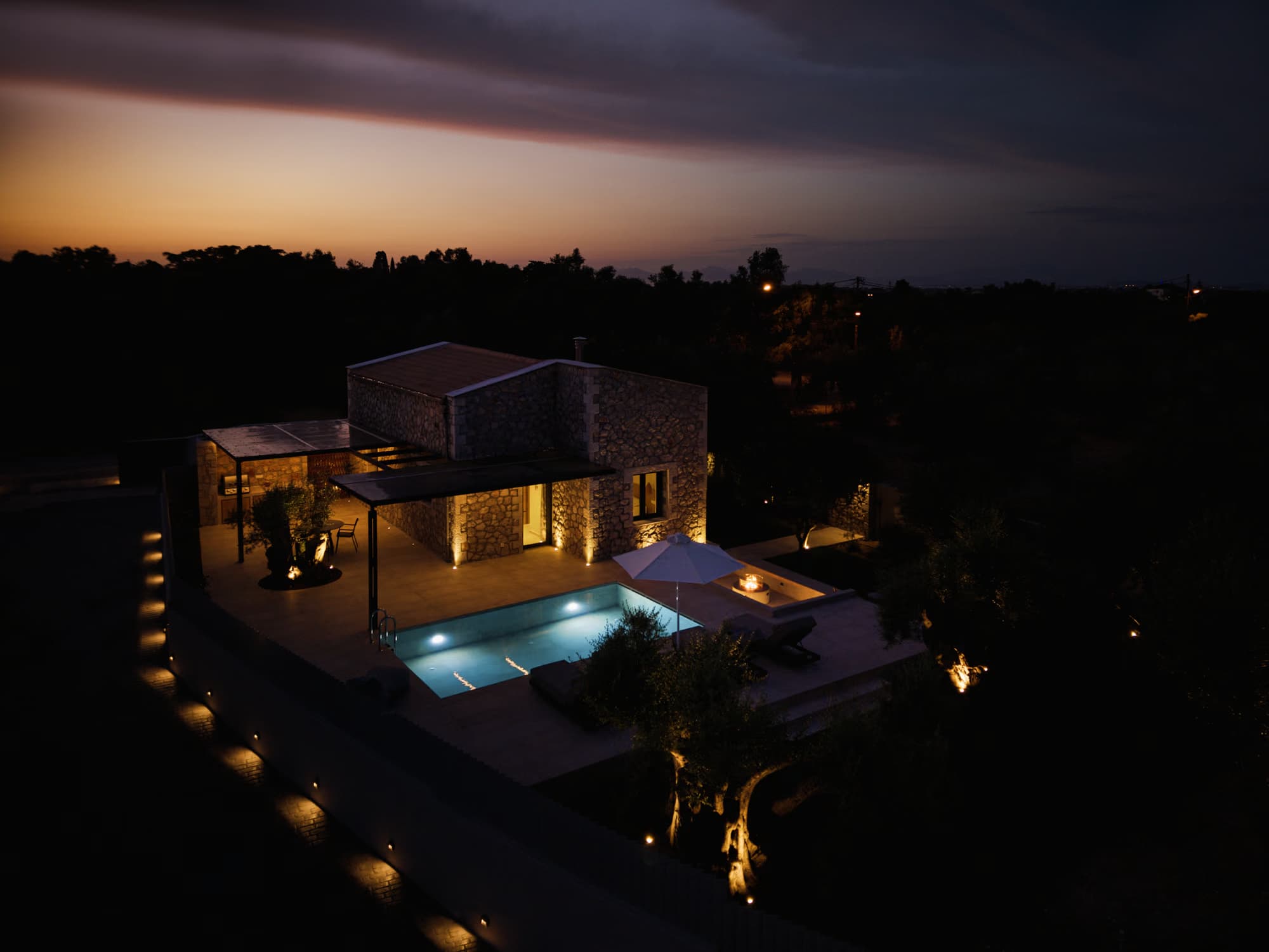 Revello Villa 1 lit up at night with the pool glowing