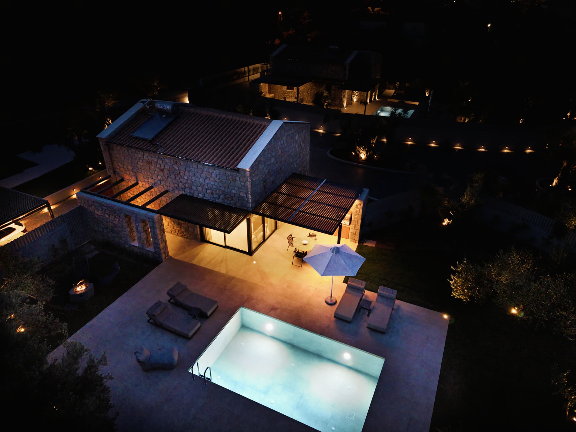 Drone view of a Revello villa lit up at night, Lefkada