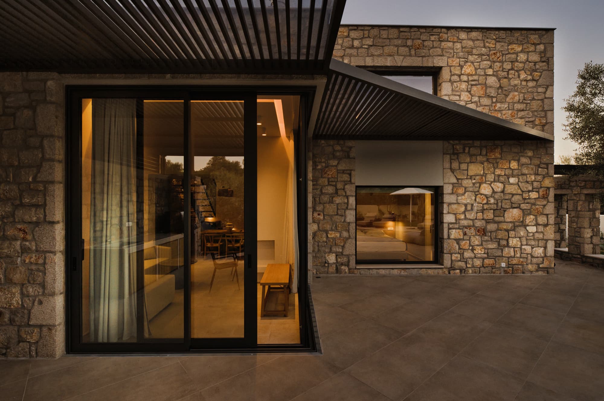 Revello Villa 3 glass doors glowing at dusk