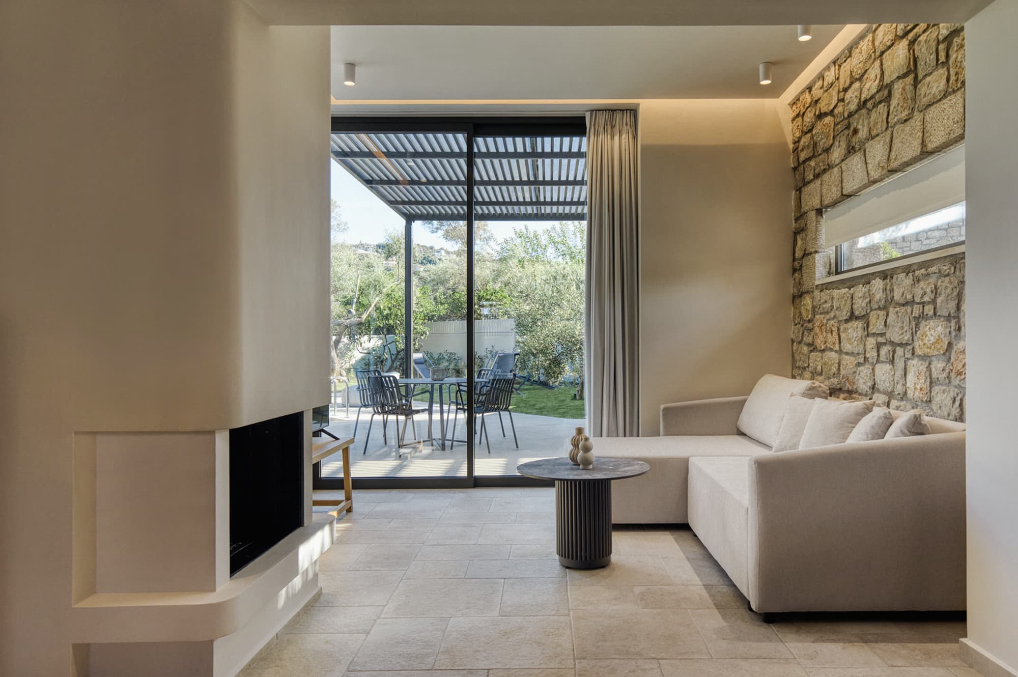 Revello Villa 4 sofa and fireplace beside glass doors to the terrace