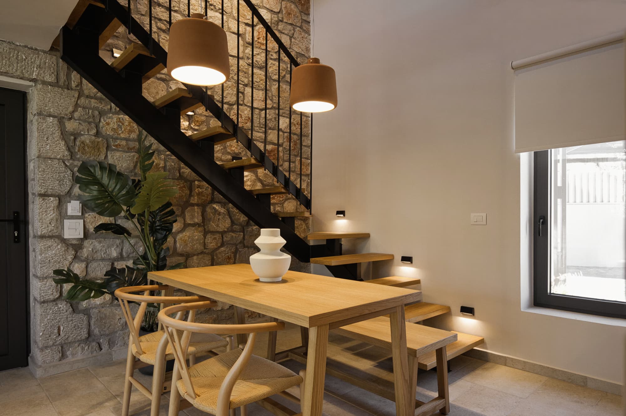 Revello Villa 4 dining table beside the stone stair wall